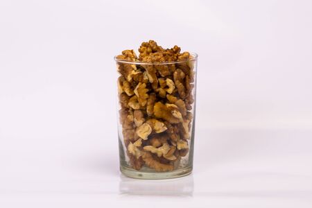 A glass of walnuts. Peeled nuts on a white background.