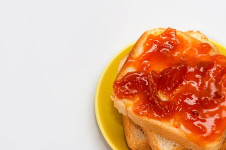 Bread and apricot jam on a white background. toast with jam. Dessert for breakfast. Slices of bread with jam. High-calorie sandwiches.の写真素材