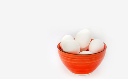 Raw white chicken eggs in a plate on a white background. Cooking scrambled eggs for breakfast. protein diet breakfastの写真素材