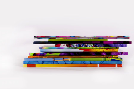 A stack of books on a white background. Books on the tables in the university library. Lots of books with colorful covers. Children's books for readingの写真素材