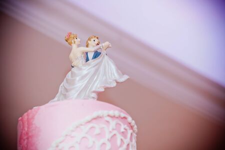 pink white wedding cake couple on topの写真素材