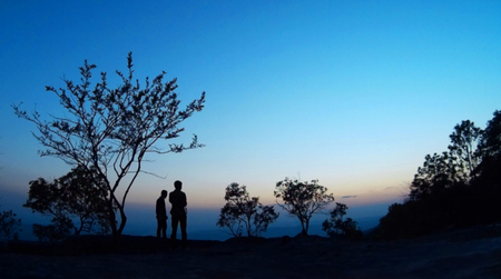 Blurred and Silhouettes background of men who see the sunrise on the mountain with clear sky.の写真素材