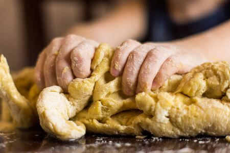 children's hands diligently preparing bread