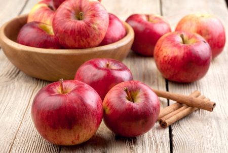 A bowl of red apples on the wooden tableの写真素材