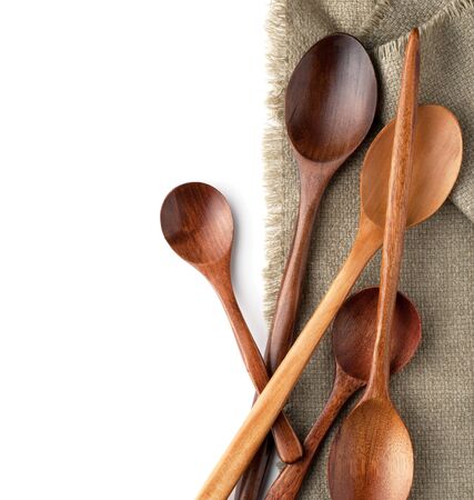 Wooden spoons on a kitchen towel isolated on white backgroundの写真素材