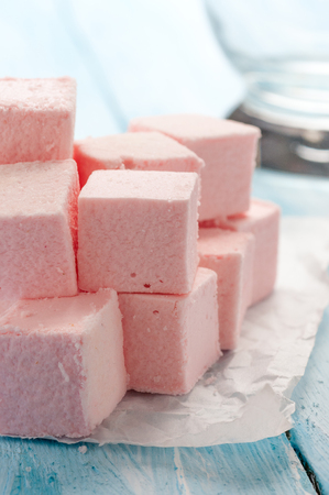 pink marshmallows candy on blue wooden tableの写真素材