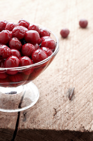 cherry compote in a glass vase on wood backgroundの写真素材