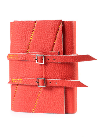 Red Leather Closed Paper Notepad With Buckles Isolated On White Backgroundの写真素材