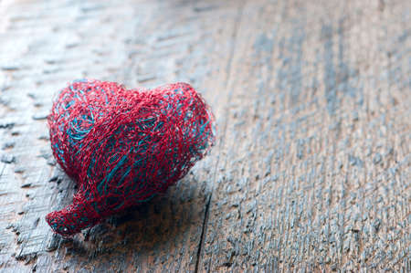 The heart of bent wire  on wood backgroundの写真素材