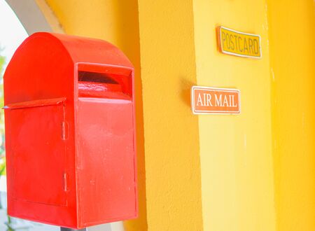 Red postbox in yellow background