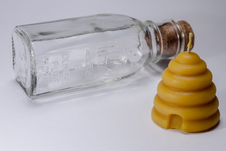 Beehive candle with empty honey containerの写真素材