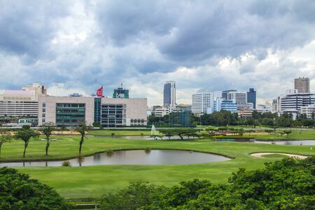 The landscape of golf courses in Bangkok, a retail district dominated by towers and skyscrapers, surrounds.の写真素材
