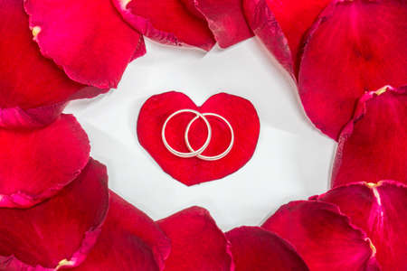 Ring, red heart surrounded with rose petals.の写真素材
