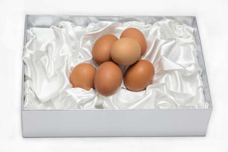Eggs in the box decorated with white cloth on white backgroung.の写真素材