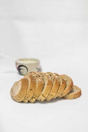 Oatmeal bread with soy milk in a ceramic cup and spoon.の写真素材