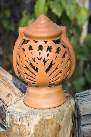 Brown pottery lamp is located on a garden walkway.の写真素材