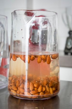 Glass jar filled with water and almonds producing almond milk