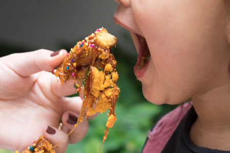 Girl eating Turron dona pepa dough with honey traditional peruvian dessertの写真素材