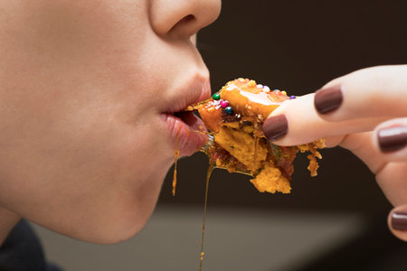 Girl eating Turron dona pepa dough with honey traditional peruvian dessertの写真素材