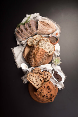 Different types of bread on a dark background. Select focus. Freshly baked wheat bread loaf...