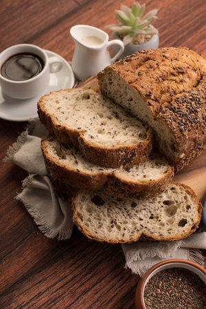 Bread with sesame seeds and cup of coffee on wooden table Freshly baked wheat bread loaf breakfast...
