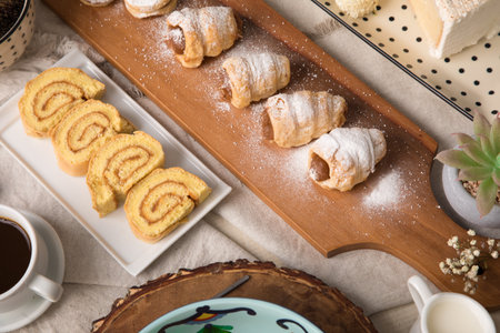 Cup of coffee and sweet rolls on wooden tray, top view Assorted peruvian desserts peru sweet food...