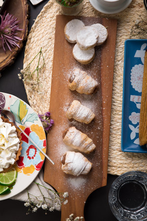Homemade guargueros with whipped cream and sugar on a wooden board Assorted peruvian desserts peru...