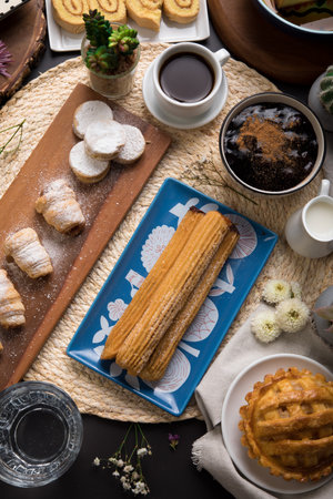 Eclairs with coffee and cookies on the table, top view Assorted peruvian desserts peru sweet food...