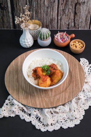 Fried potato with curry sauce and rice in white bowl on wooden table Peruvian buffet table Assorted food dishes gourmet sea food Peru traditionalの写真素材