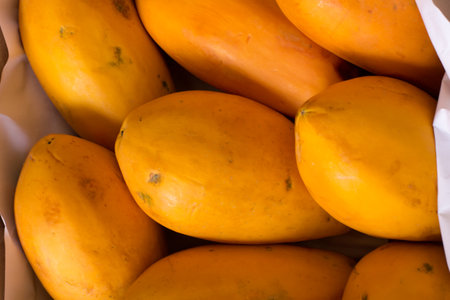 Ripe papaya fruit in a paper bag on a market stallの写真素材