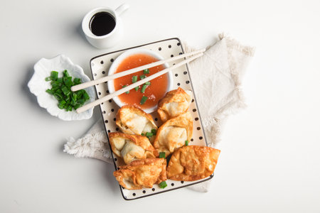 Fried dumplings with sauce and chopsticks on a white backgroundの写真素材