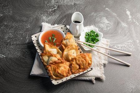 Fried dumplings with sauce and chopsticks on a black backgroundの写真素材