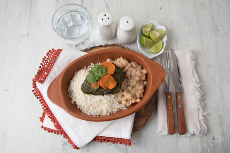 Seco de carne con frejoles beef stew coriander and beans peruvian food Rice with chickpeas and spinach in a bowl on a wooden tableの写真素材