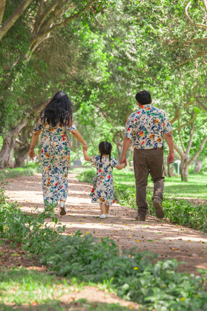 Happy asian family walking in the park. Father, mother and daughter walking in the park.の写真素材