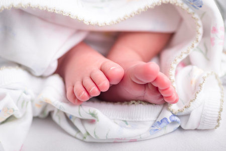 Newborn baby feet on a white background, close-up.