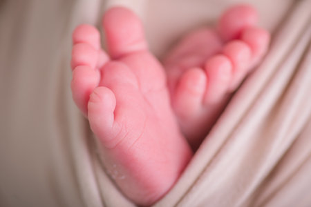 Feet of a newborn baby on a beige blanket. Soft focus.の写真素材