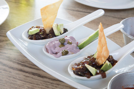 Tuna tartare and olive octopus Sea food on chinese spoons on a plate in a restaurant. Peruvian foodの写真素材