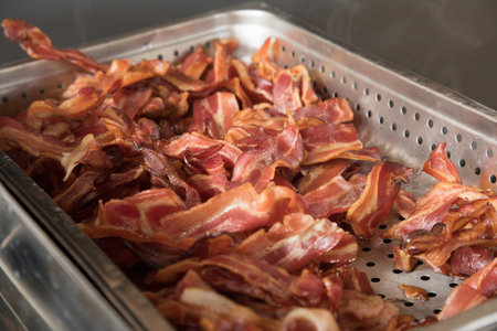 Smoked bacon in stainless steel tray. Selective focus on bacon.の写真素材