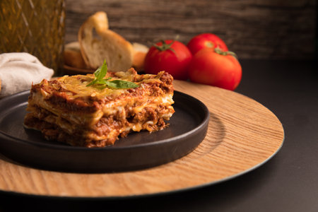 Traditional Italian lasagna bolognese served on a black plateの写真素材