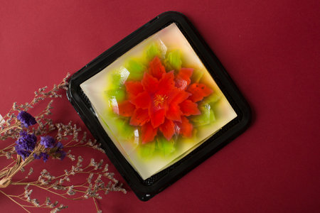 Fruit jelly in a black box on a red background, top view