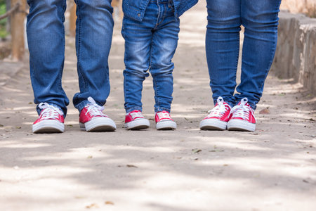 Legs of a young couple in sneakers walking in the park.の写真素材