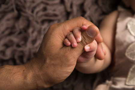 Close-up of a hand of a little baby holding his father's handの写真素材