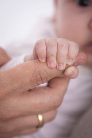 Mother holding her newborn baby hand, shallow DOF, focus on the hand