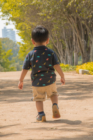 Boy walking in the park, shallow depth of field, blur background
