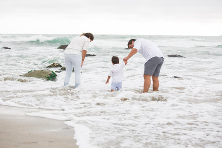 Happy family playing together on the beach at the day time. Concept of friendly family.の写真素材