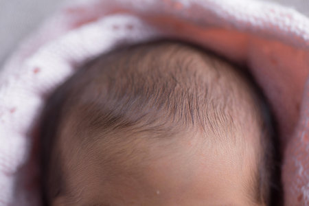 Newborn baby in pink towel, close-up, selective focus