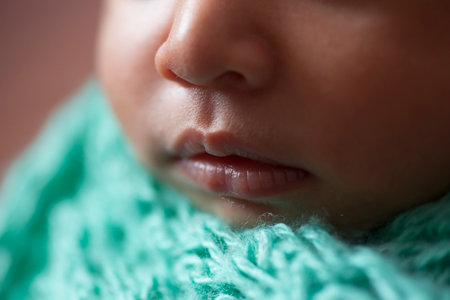 Close up portrait of a newborn baby in a green knitted scarfの写真素材