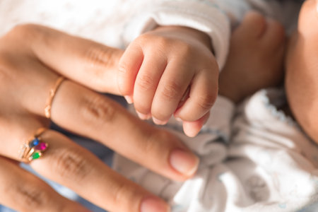 Close up of newborn baby's hand holding mother's hand, family concept