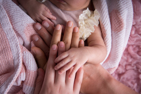 Close up of mother's hands holding newborn baby's hand. Family conceptの写真素材
