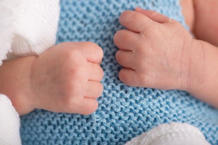 Newborn baby's feet on blue knitted blanket, closeup